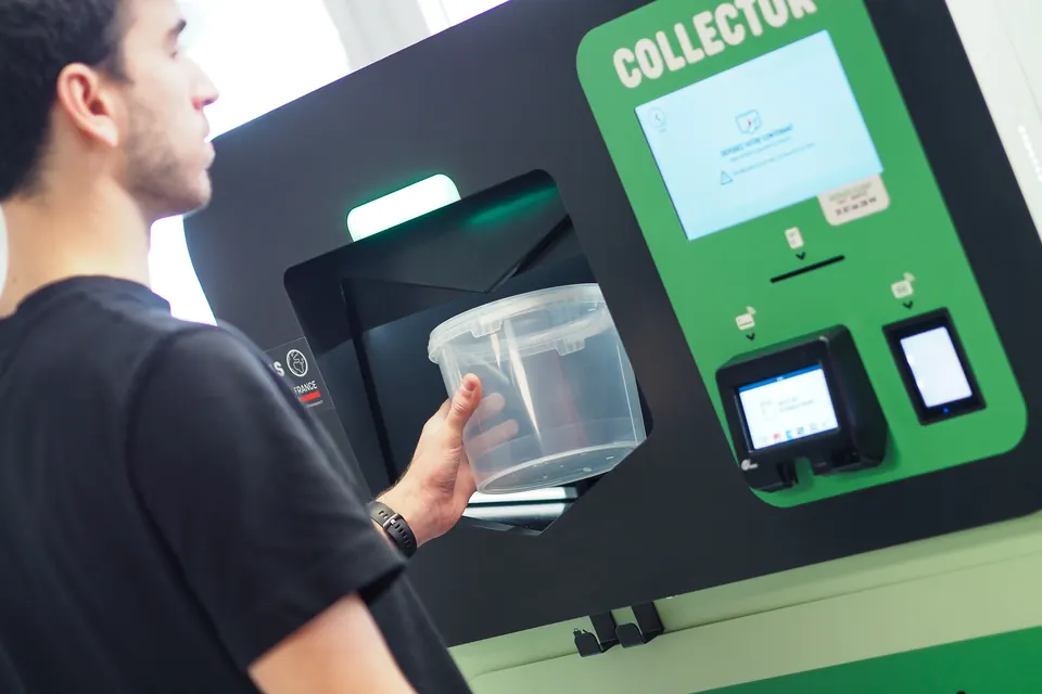 Un client dépose une barquette en plastique consignée dans le Collector